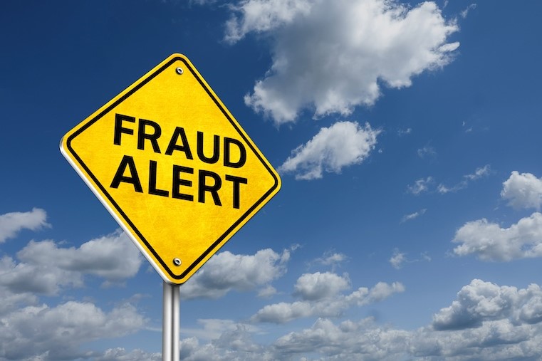 fraud alert on yellow road sign