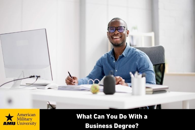 what-can-you-do-with-a-business-degree business degree student smiling at desk